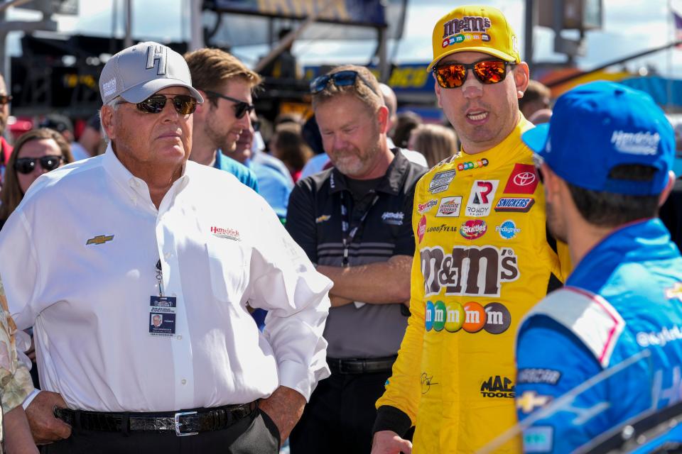 Team owner Rick Hendrick talks with NASCAR Cup Series driver Kyle Busch (18) and Hendrick driver Kyle Larson (5) during the Bank of America Roval 400 at Charlotte Motor Speedway Road Course.