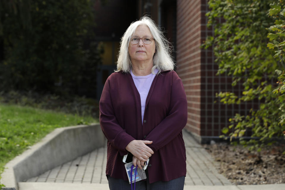 In this Sept. 12, 2019, photo, Cynthia Yost, who used to teach at the Sky Valley Education Center in Monroe, Wash., poses for a photo in Mercer Island, Wash. Yost was among teachers who sent pieces of carpet and classroom air filters to a lab that found elevated levels of PCBs, toxic chemicals used as coolant in old fluorescent light ballasts. (AP Photo/Ted S. Warren)