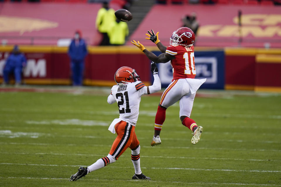 Kansas City Chiefs wide receiver Tyreek Hill (10) catches a pass over Cleveland Browns cornerback Denzel Ward (21) during the second half of an NFL divisional round football game, Sunday, Jan. 17, 2021, in Kansas City. (AP Photo/Jeff Roberson)