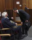 Olympic and Paralympic track star Oscar Pistorius speaks to his legal representative Barry Roux (C) during Pistorius' trial for the murder of his girlfriend Reeva Steenkamp, at the North Gauteng High Court in Pretoria, March 3, 2014. The first witness at Pistorius' murder trial told the court on Monday she heard "bloodcurdling screams" from a woman followed by shots, a dramatic opening to a case that could see one of global sports' most admired role models jailed for life. Pistorius pleaded not guilty to murdering model Steenkamp on Valentine's Day last year. REUTERS/Themba Hadebe/Pool (SOUTH AFRICA - Tags: SPORT ATHLETICS ENTERTAINMENT CRIME LAW)