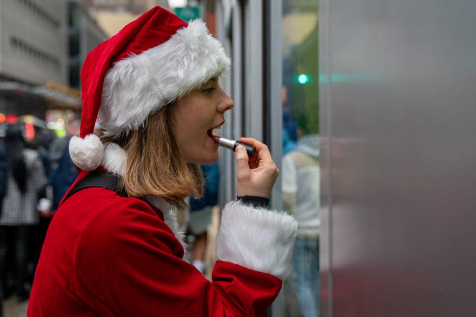 A person dressed in a Santa Claus costume puts on make-up during SantaCon in New York City. (Photo by David Dee Delgado/Getty Images)<br>