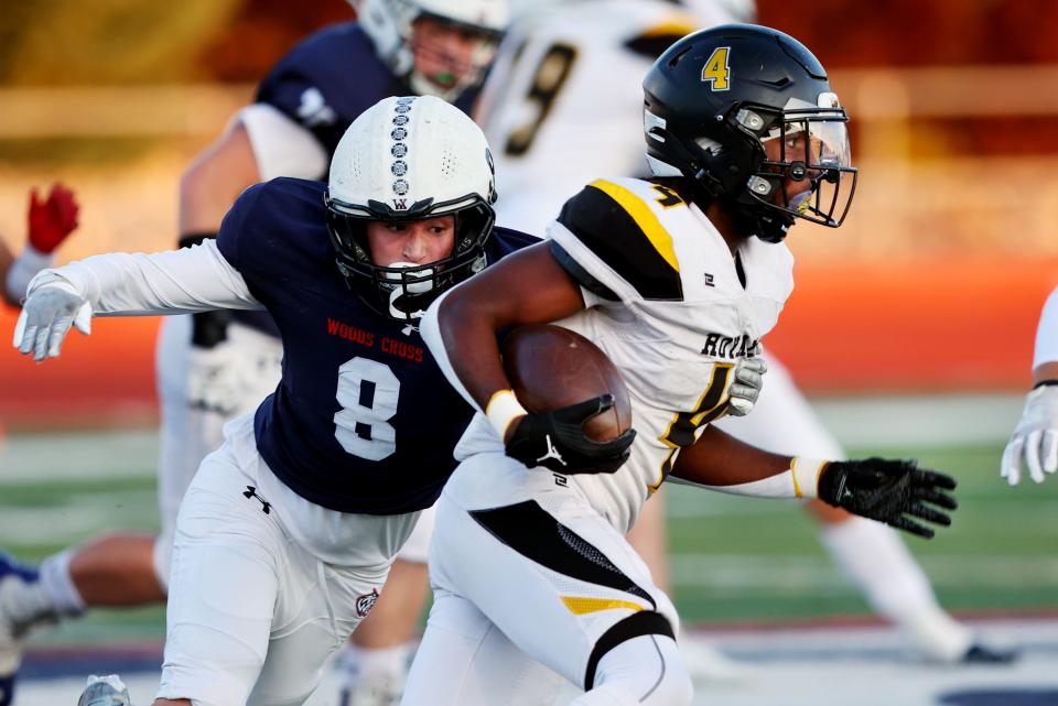 Roy’s DaeQwan Snider works to get away from Woods Cross’ Cash Sudbury as they play at Woods Cross High School on Friday, Sept. 22, 2023.