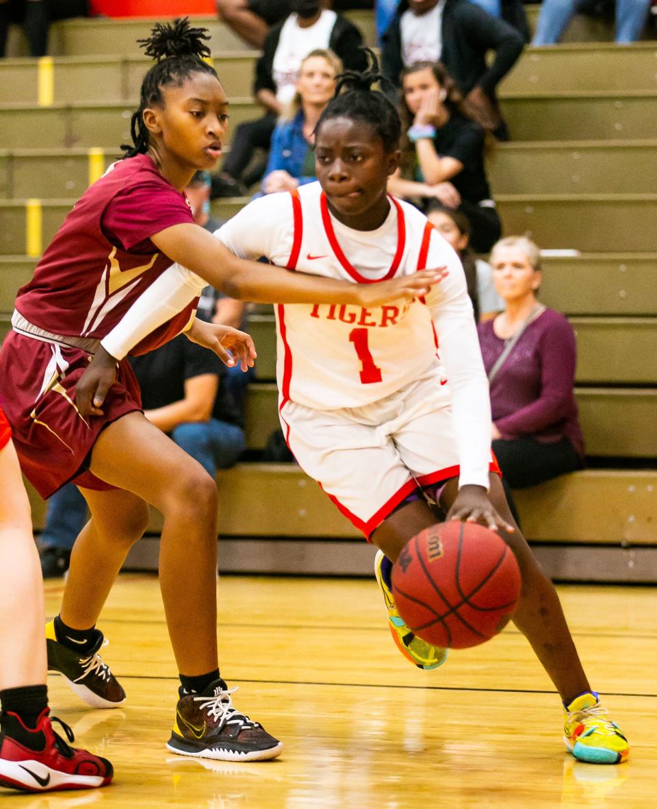 Dunnellon's Kmari Williams drives through North Marion's E'niah Tensley. The Dunnellon Tigers defeated the North Marion Colts 71-67 in a girls district basketball game Wednesday night, Jan. 19, 2022, in Dunnellon.