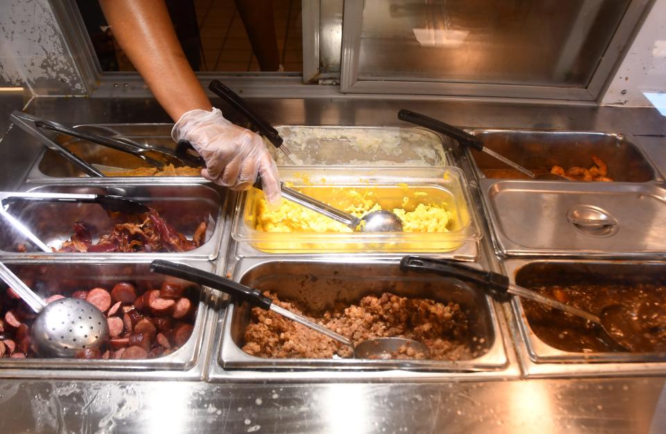 Line cook Janasia Sneed prepares healthy, hot breakfast meals to go at the Evans Center and market, a vital hub in a low- to moderate-income area in Melbourne and Palm Bay.