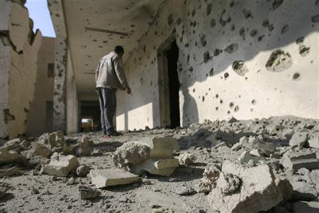 A man inspects the site of a mortar attack in the city of Falluja, 70 km (44 miles) west of Baghdad January 16, 2014. REUTERS/Stringer