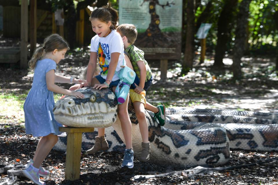 Children play on a large snake sculpture during a field trip Tuesday at the Emerald Coast Science Center. The science center was recently recognized by the Association of Science and Technology Centers for overcoming the many obstacles posed by the pandemic.