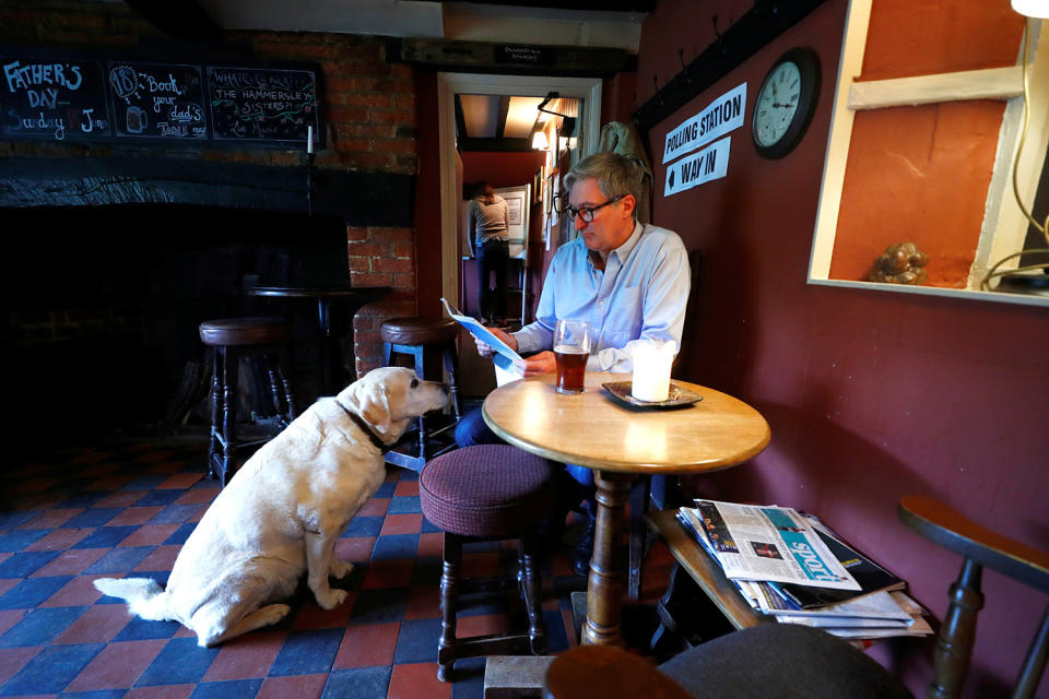 <p>A man sits with his dog inside the Fox and Hounds public house used as a temporary polling station in Christmas Common, Britain, June 8, 2017. (Photo: Eddie Keogh/Reuters) </p>