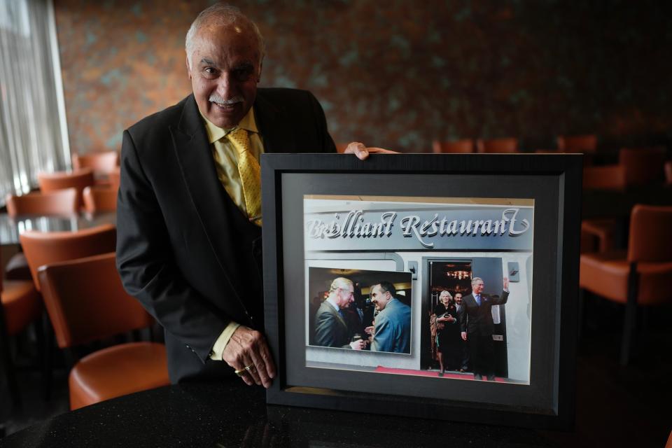 Gulu Anand, owner of the Indian restaurant 'Brilliant', holds the photos of King Charles III visiting his restaurant in the district of Southall in London, Tuesday, Sept. 13, 2022. In a church in a West London district known locally as Little India, a book of condolence for Queen Elizabeth II lies open. Five days after the monarch’s passing, few have signed their names. The congregation of 300 is made up largely of the South Asian diaspora, like the majority of the estimated 70,000 people living in the district of Southall, a community tucked away in London's outer reaches of London and built on waves of migration that span 100 years. (AP Photo/Kin Cheung)