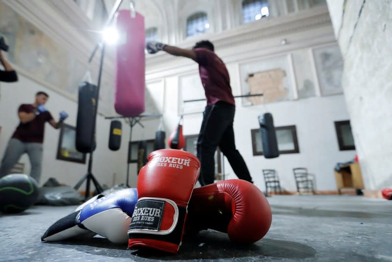 Boxing gloves lie on the floor as Nico Rodrigues, 21, trains during a boxing class at the Santa Maria della Sanita Basilica in the Rione Sanita neighbourhood in Naples