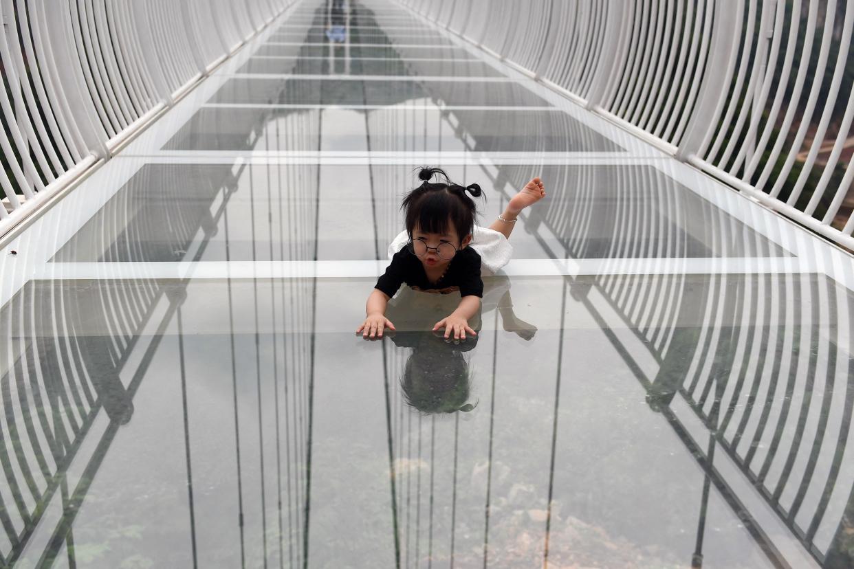 a child lies down on the Bach Long glass bridge in the Moc Chau district in Vietnam's Son La province