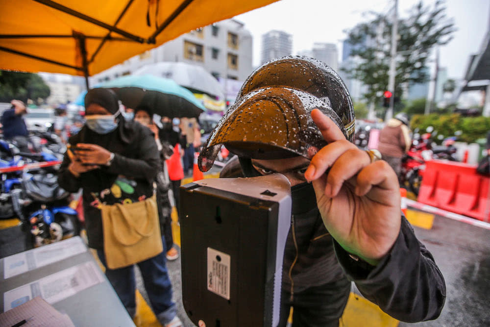 A man checks his body temperature at the Kampung Baru Ramadan bazaar April 14, 2021. ― Picture by Hari Anggara