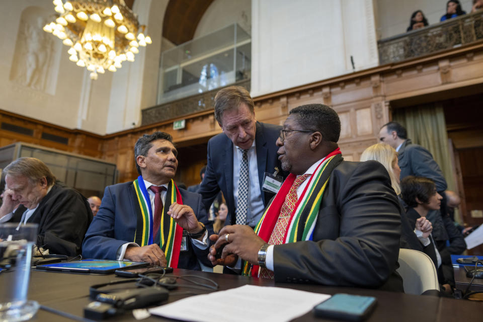 South Africa's agents Vusimuzi Madonsela, seated right, and Cornelius Scholtz, seated second left, talk prior to the start of hearings at the International Court of Justice, in The Hague, Netherlands, Thursday, May 16, 2024. The U.N.'s top court opened two days of hearings in a case brought by South Africa to see whether Israel needs to take additional measures to alleviate the suffering in war-ravaged Gaza. (AP Photo/Peter Dejong)