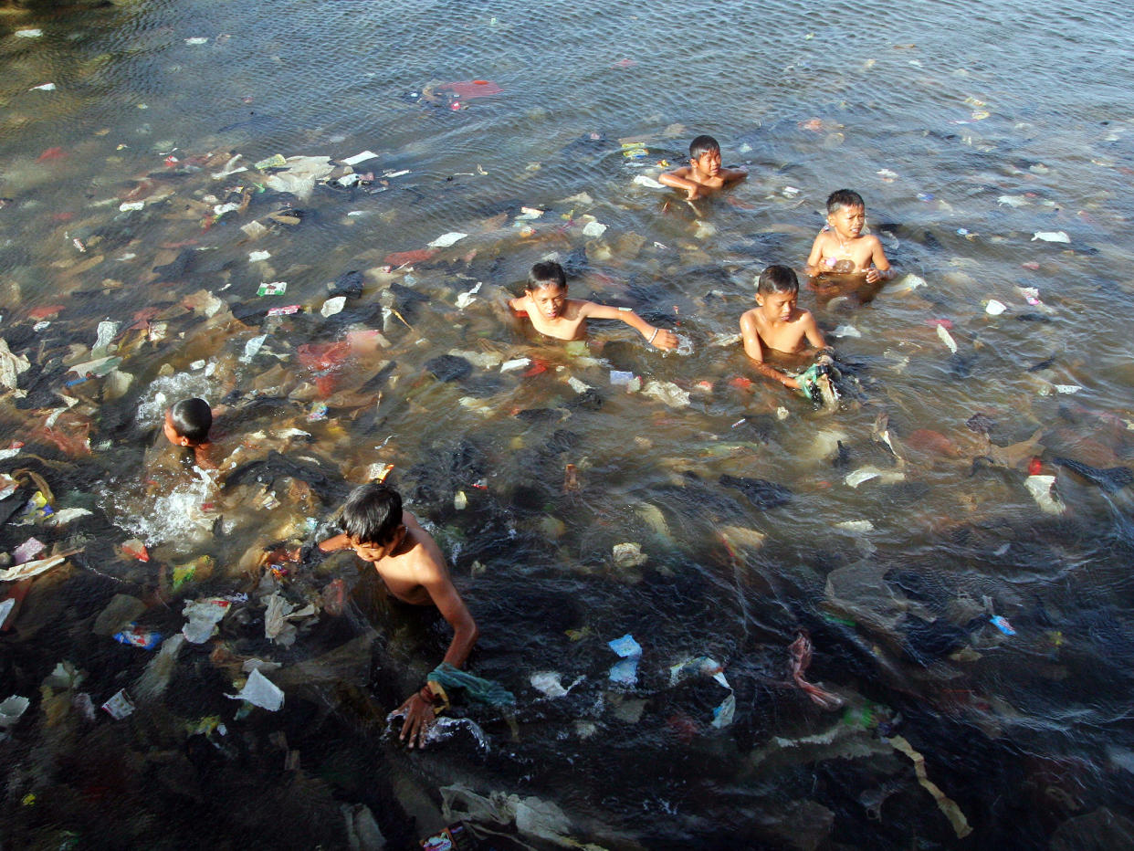 Plastic is polluting the world’s oceans: children swim in a sea full of garbage in North Jakarta, Indonesia: Getty