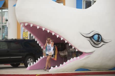 Sarah Malone walks out of Moby Dicks gift shop after doing some last minute shopping before heading home from spring break festivities in Panama City Beach, Florida March 13, 2015. REUTERS/Michael Spooneybarger