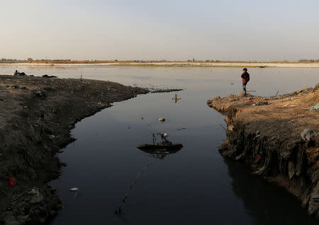 A boy stands next to an open drain on the banks of river Ganges in Kanpur, India, April 3, 2017. REUTERS/Danish Siddiqui