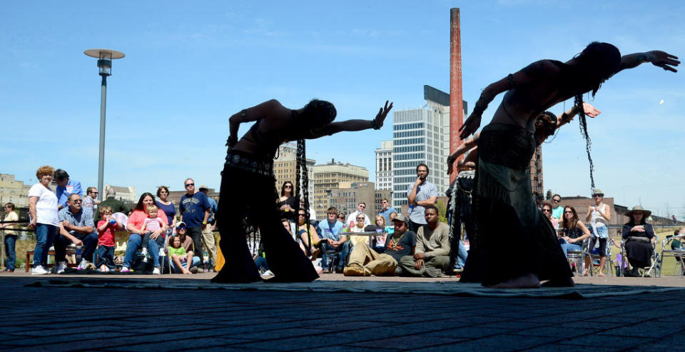 In an April 6, 2013 photo Erynias Tribe bellydancers dance to the music of Juka Tribe at the Darter Festival in Railroad Park in Birmingham Ala. Long haunted by black-and-white newsreel footage of the fire hoses and police dogs city leaders turned on blacks demonstrating for civil rights, the city has a new vibe that's generating buzz all its own 50 years later. (AP Photo/AL.com, Mark Almond) MAGS OUT