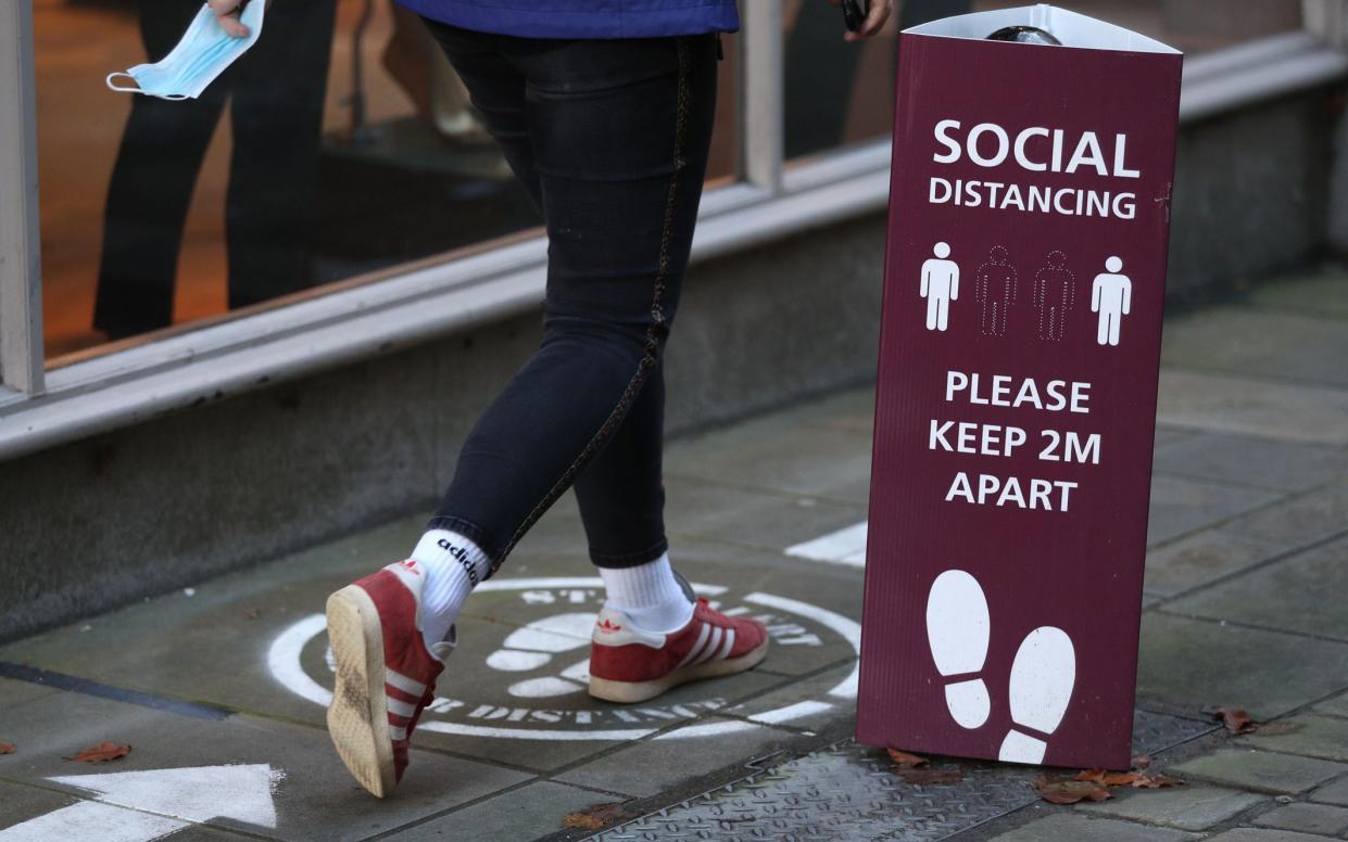 A person walks past a social distancing sign near the High Street in Winchester, Hampshire, ahead of a national lockdown for England from Thursday. PA Photo. Picture date: Tuesday November 3, 2020. See PA story HEALTH Coronavirus.  - Andrew Mathews/PA Wire