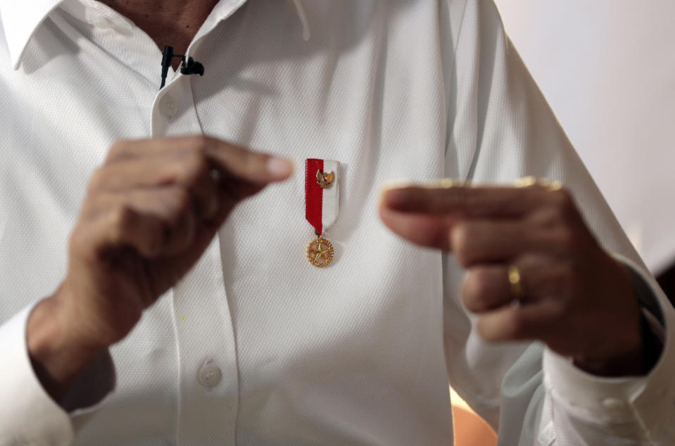 Indonesian President Joko Widodo wears a presidential pin during an interview with The Associated Press in Jakarta, Indonesia, Friday, July 26, 2019. In the wide-ranging interview, Widodo outlined his priorities for his second term, including continuing large-scale infrastructure projects and simplifying a cumbersome bureaucracy. He said labor laws will be overhauled in what will be a politically challenging decision to attract more investment and create more jobs. (AP Photo/Dita Alangkara)