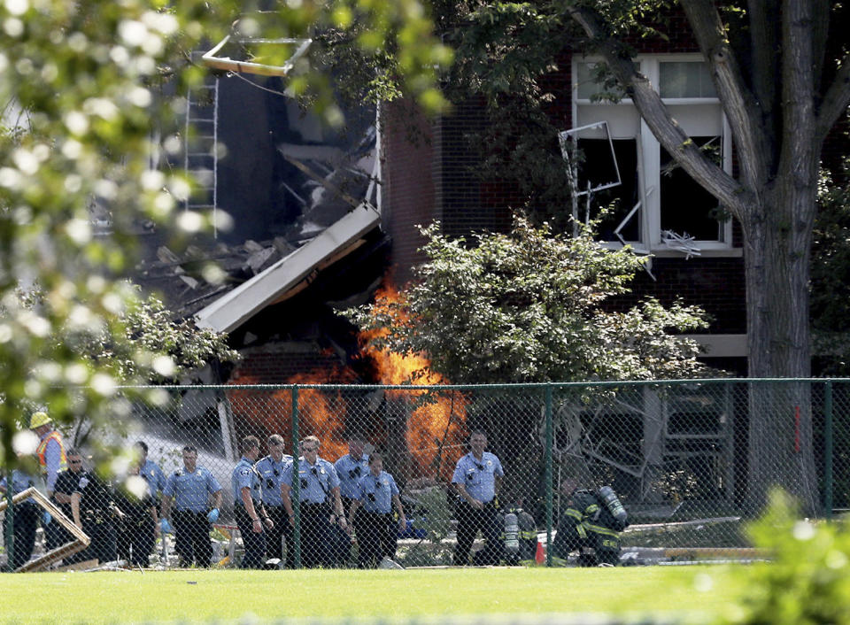 <p>Emergency personnel move away as a gas fire continues to burn following an explosion at Minnehaha Academy Aug. 2, 2017, in Minneapolis. Several people are unaccounted for after an explosion and partial building collapse Wednesday at a Minneapolis school, fire officials said. (David Joles/Star Tribune via AP) </p>