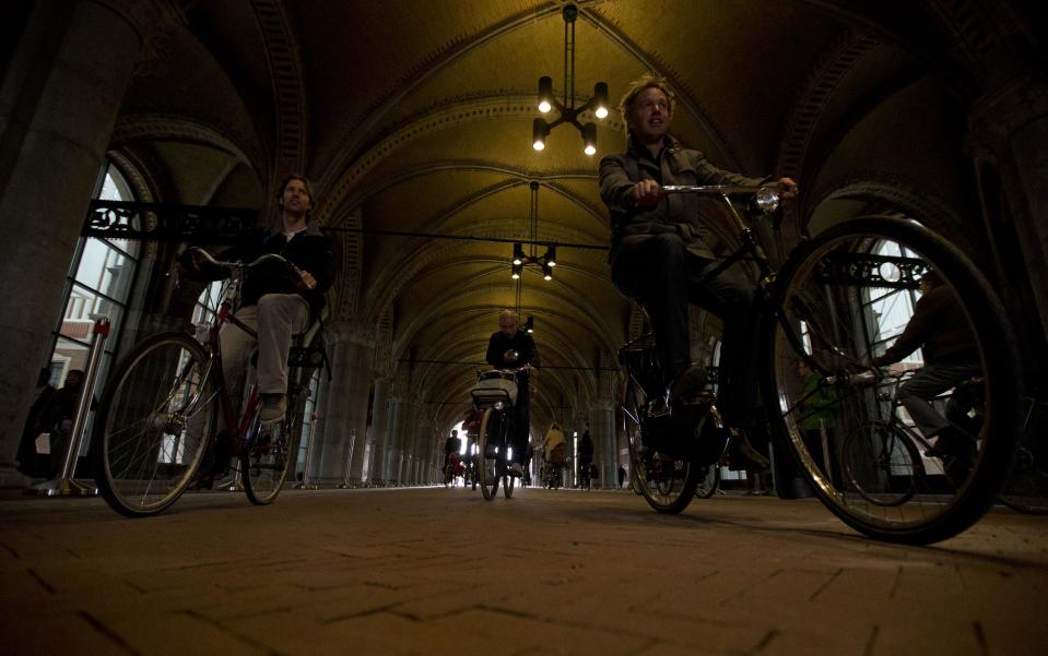 Bicycles pass through the reopened bike path under Rijksmuseum in Amsterdam Monday May 13, 2013. Hundreds of bicycles pedaled triumphantly through Rijksmuseum, signaling the end of more than a decade of efforts by cyclists to ensure a passageway that runs under and through the Rijksmuseum would remain open to bike traffic. The museum, which houses masterpieces by Rembrandt van Rijn and Vincent van Gogh, among others, opened last month after a 10-year renovation. Architects and successive museum directors had opposed allowing bikes through, and a local government tried to have them barred on safety grounds. But in a city that has more bicycles than people, the bike lobby prevailed. (AP Photo/Peter Dejong)