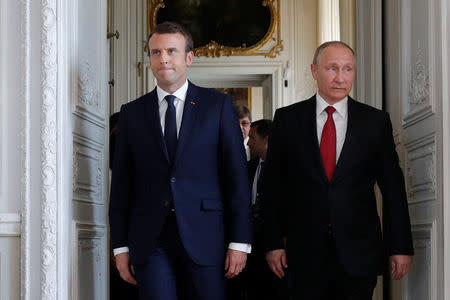 French President Emmanuel Macron (L) walks with Russian President Vladimir Putin at the Chateau de Versailles as they meet for talks before the opening of an exhibition marking 300 years of diplomatic ties between the two countries in Versailles, France, May 29, 2017. REUTERS/Philippe Wojazer