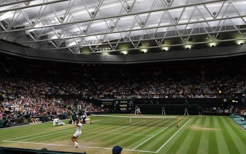 Spain's Rafael Nadal (L) throws the ball to serve against Serbia's Novak Djokovic during their men's singles semi-final match under the closed roof on Centre Court, on the eleventh day of the 2018 Wimbledon Championships - Credit: GLYN KIRK/AFP/Getty Images