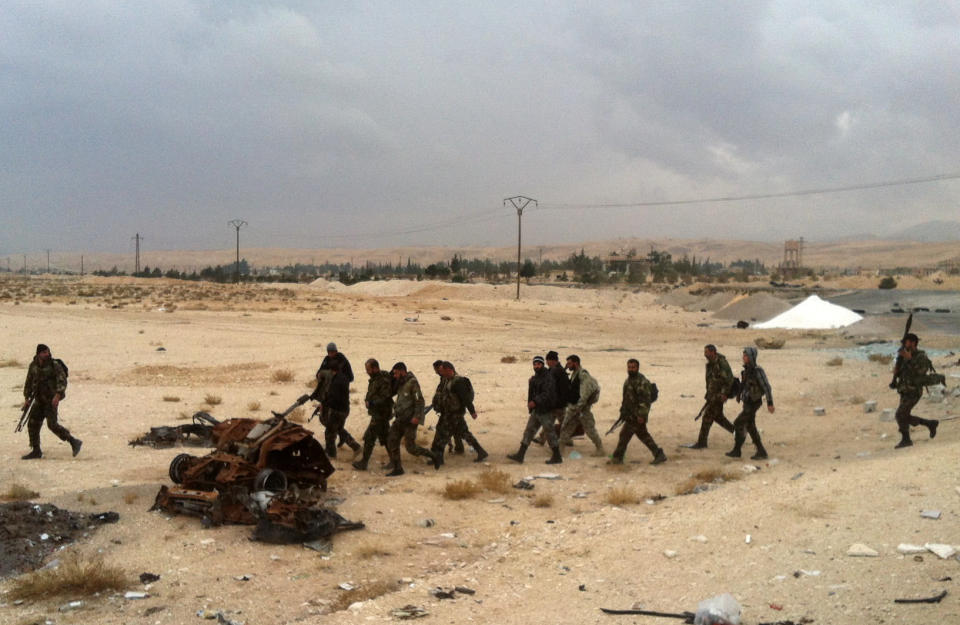 A picture taken on December 3, 2013 shows pro regime forces walking with their weapons near al-Nabak, in the Qalamoun region on the outskirts of the capital Damascus, where they battle with rebel fighters. (SAM SKAINE/AFP/Getty Images)