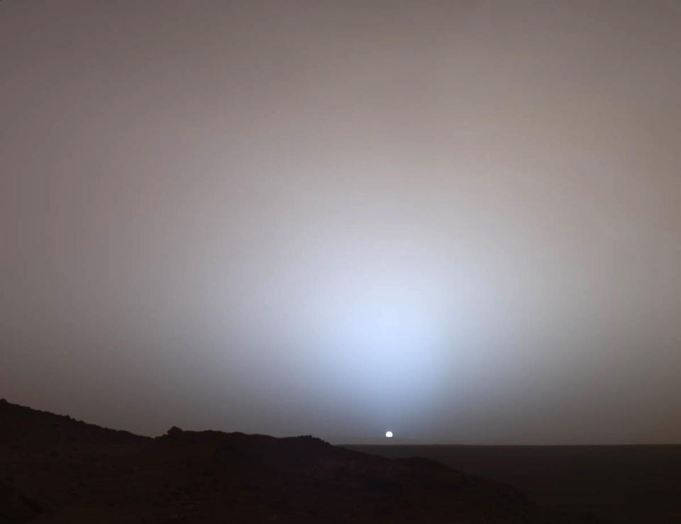 This image provided by NASA shows a view by the Mars Rover Spirit of a sunset over the rim of Gusev Crater, about 80 kilometers (50 miles) away. Taken from Husband Hill, it looks much like a sunset on Earth, a reminder that other worlds can seem eerily familiar. Sunset and twilight images help scientists to determine how high into the atmosphere the Martian dust extends and to look for dust or ice clouds. Ten years after NASA landed two rovers on Mars on a 90-day mission, one rover is still exploring, and the project has generated hundreds of thousands of images from the Martian surface. Now the Smithsonian’s National Air and Space Museum is presenting more than 50 of the best photographs from the two Mars rovers in an art exhibit curated by the scientists who have led the ongoing mission. (AP Photo/NASA/JPL-Caltech/Texas A&M/Cornell University)