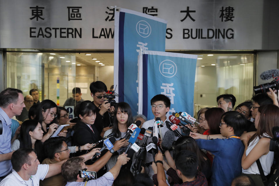 Pro-democracy activists Joshua Wong, right, and Agnes Chow speak to media outside a district court in Hong Kong, Friday, Aug. 30, 2019. Wong and Chow were granted bail Friday after being charged with inciting people to join a protest in June, while authorities denied permission for a major march in what appears to be a harder line on this summer's protests. (AP Photo/Kin Cheung)