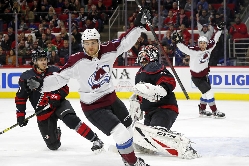 Colorado Avalanche's Tyson Jost (17) celebrates his goal against Carolina Hurricanes goaltender Anton Forsberg, second from right, with Hurricanes' Trevor van Riemsdyk (57) nearby during the first period of an NHL hockey game in Raleigh, N.C., Friday, Feb. 28, 2020. (AP Photo/Karl B DeBlaker)