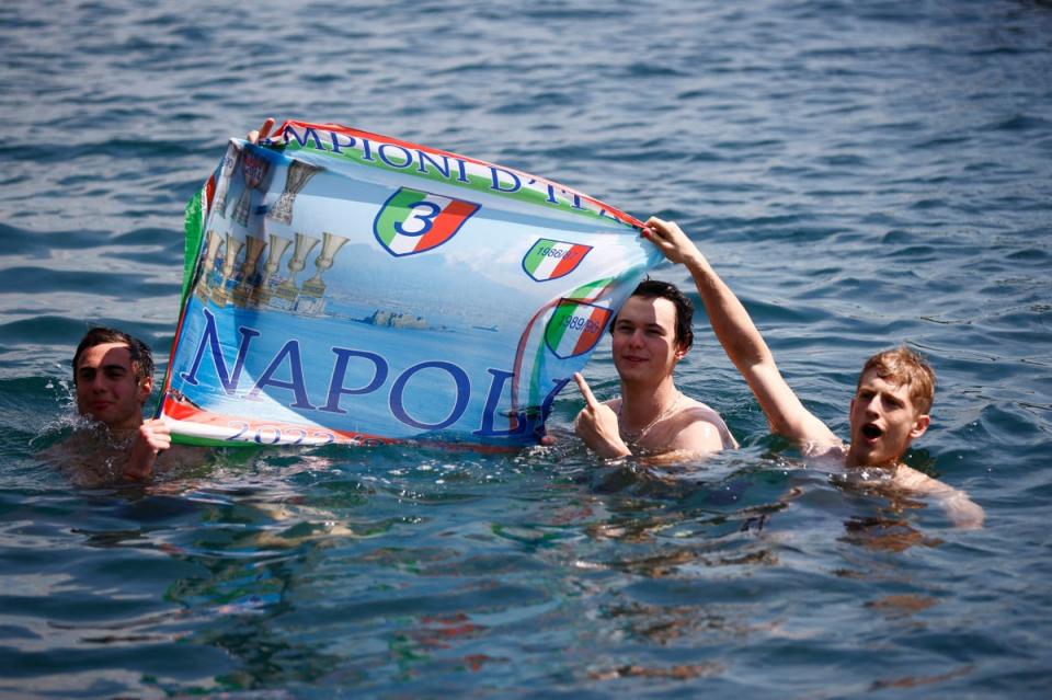 Napoli fans display a banner while swimming, the day after Napoli won their first Serie A title in 33 years (REUTERS)