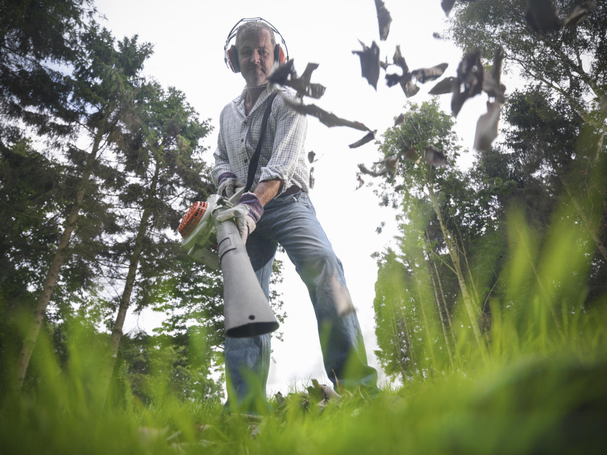 Man using a gas leaf blower.