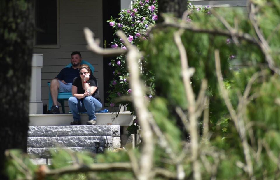 Residents sit on their steps watching the clean up after a tornado hit North Street in Mattapoisett. The tornado touchdown about 11:30 a.m. on Aug 8. The National Weather Service is still investigating the details.