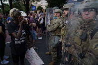 Soldiers with Utah National Guard stand near a group of demonstrators that gathered to protest the death of George Floyd, Wednesday, June 3, 2020, near the White House in Washington. Floyd died after being restrained by Minneapolis police officers. (AP Photo/Evan Vucci)