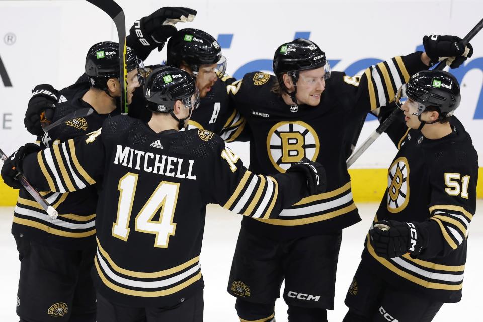 Boston Bruins' David Pastrnak (88) celebrates his goal with teammates Ian Mitchell (14), Kevin Shattenkirk, left, Oskar Steen (62) and Matthew Poitras (51) during the first period of an NHL hockey game against the Arizona Coyotes, Saturday, Dec. 9 2023, in Boston. (AP Photo/Michael Dwyer)