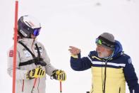 Kiana Kryeziu, left, listens to Kosovo's national team coach Agim Pupovci during training at the Arxhena Ski center in Dragas, Kosovo on Saturday, Jan. 22, 2022. The 17-year-old Kryeziu is the first female athlete from Kosovo at the Olympic Winter Games after she met the required standards, with the last races held in Italy. (AP Photo/Visar Kryeziu)