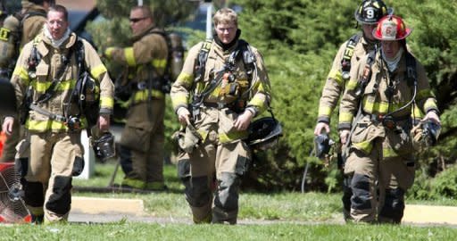 Firefighters exit the apartment of the James Holmes in Aurora, Colorado. Police believe they have defused the "remaining major threats" in alleged Batman gunman James Holmes's booby-trapped apartment, they said Saturday, adding that the devices were designed to kill