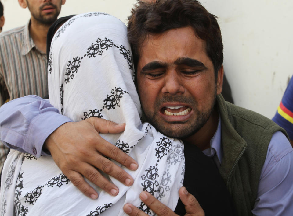Pakistani family members mourn the death of a security guard in an attack on Wednesday, Jan. 29, 2014 in Karachi, Pakistan. Police said several members of the country's security forces have been killed in separate attacks in the southern city of Karachi. (AP Photo/Fareed Khan)