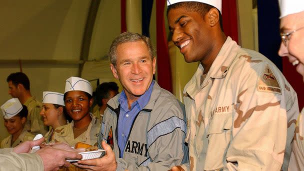 PHOTO: George W. Bush delivers food during a surprise visit on Thanksgiving Day, Nov. 27, 2003, in Baghdad. (U.s. Air Force/Getty Images)