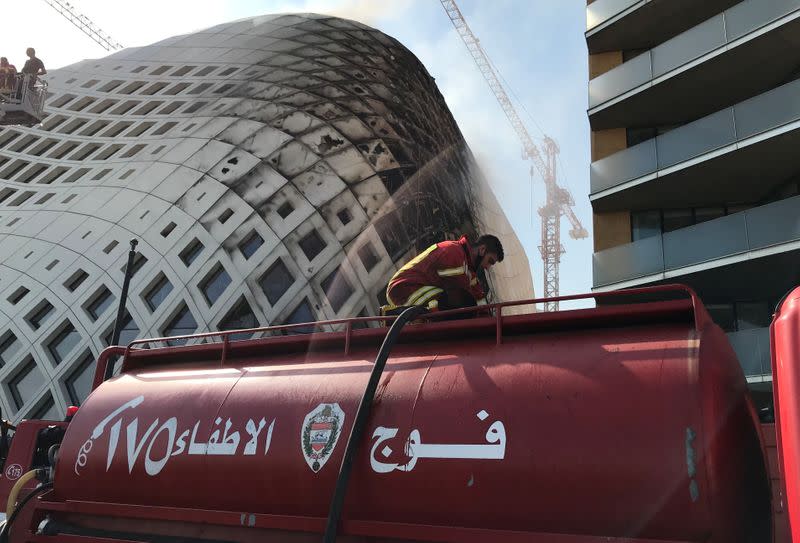 A firefighter participates in efforts to put out a fire that broke out in a building in Central Beirut