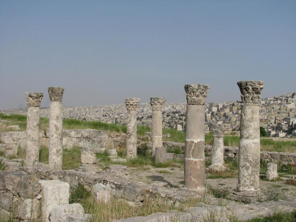 This April 21, 2016 photo shows ancient ruins on the monument-filled Citadel hill and, beyond, a panorama of Jordan's capital, Amman. This Middle Eastern country delivers a blockbuster list of iconic ancient monuments, otherworldly landscapes and warmhearted hospitality, with Petra as its tourism jewel. (Giovanna Dell'Orto via AP)