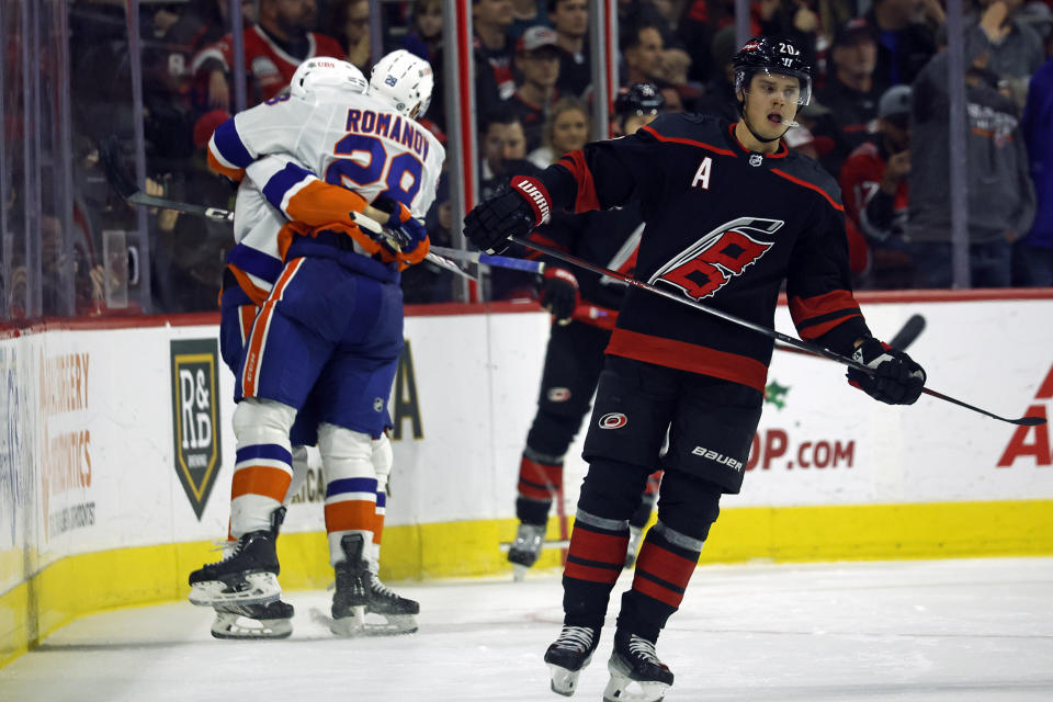 New York Islanders celebrate a shorthanded goal by Simon Holmstrom, as Carolina Hurricanes' Sebastian Aho skates past during the second period of an NHL hockey game in Raleigh, N.C., Thursday, Nov. 30, 2023. (AP Photo/Karl B DeBlaker)