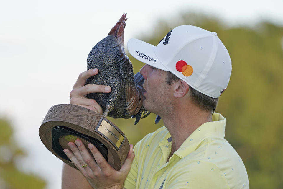 Sam Burns kisses the champion's trophy after winning the Sanderson Farms Championship golf tournament in Jackson, Miss., Sunday, Oct. 3, 2021. Burns carded 22-under par for the tournament. (AP Photo/Rogelio V. Solis)