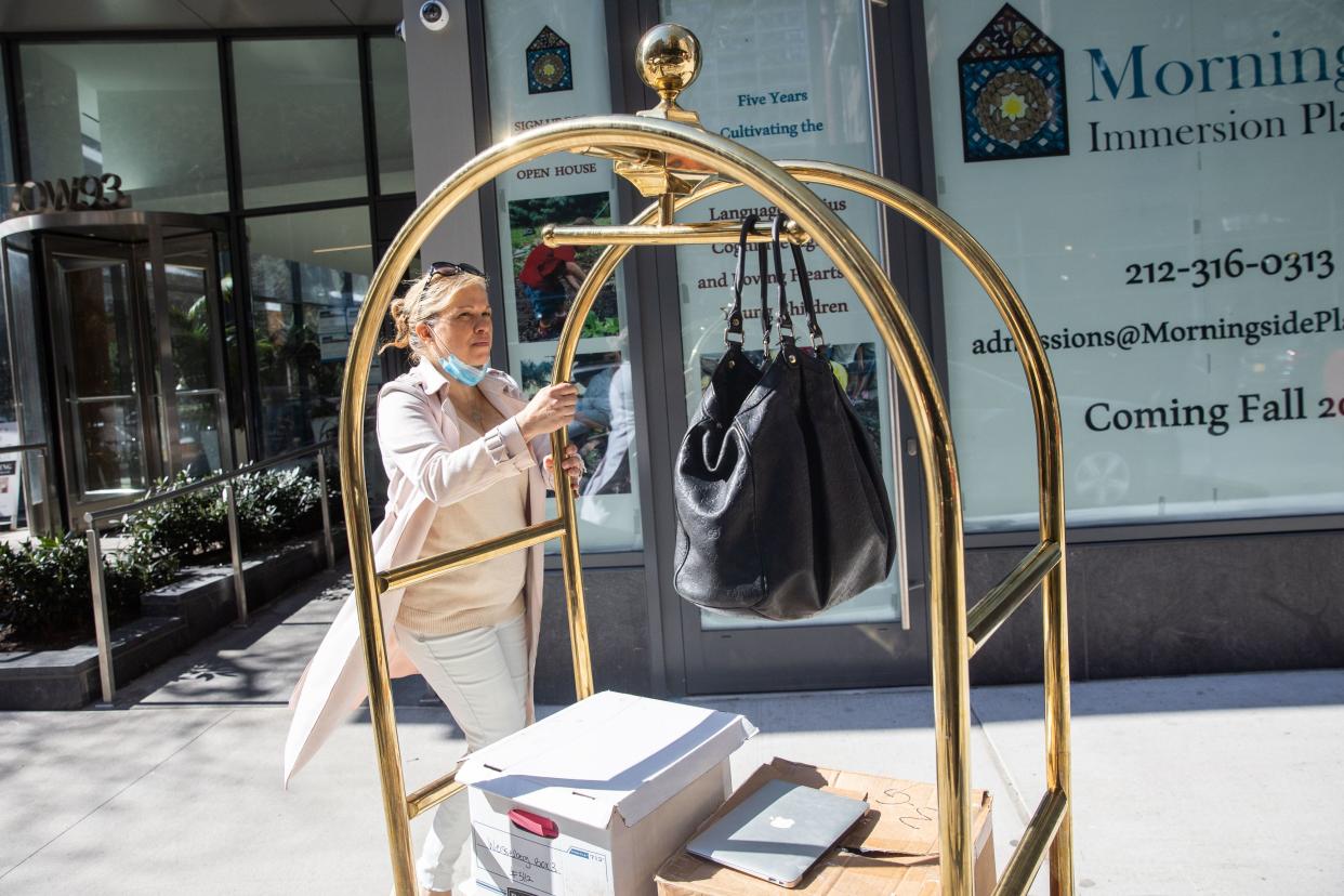 Trump Organization CFO's ex-daughter-in-law Jennifer Weisselberg carries boxes of documents and a laptop to give to prosecutors outside her apartment in Manhattan, New York on April 8. 