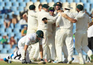 South Africa's batsman, Morne Morkel, bottom, kneels on the ground after a run out as Australia's players celebrate their winning wicket on the fourth day of their cricket test match at Centurion Park in Pretoria, South Africa, Saturday, Feb. 15, 2014. Australia beat South Africa by 281 runs. (AP Photo/ Themba Hadebe)