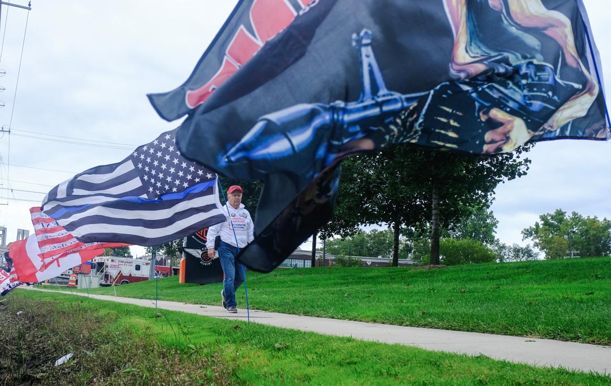 Supporters of former US President and 2024 Presidential hopeful Donald Trump walk past flags on the way to a rally in Clinton, Michigan, on September 27, 2023. (AFP via Getty Images)