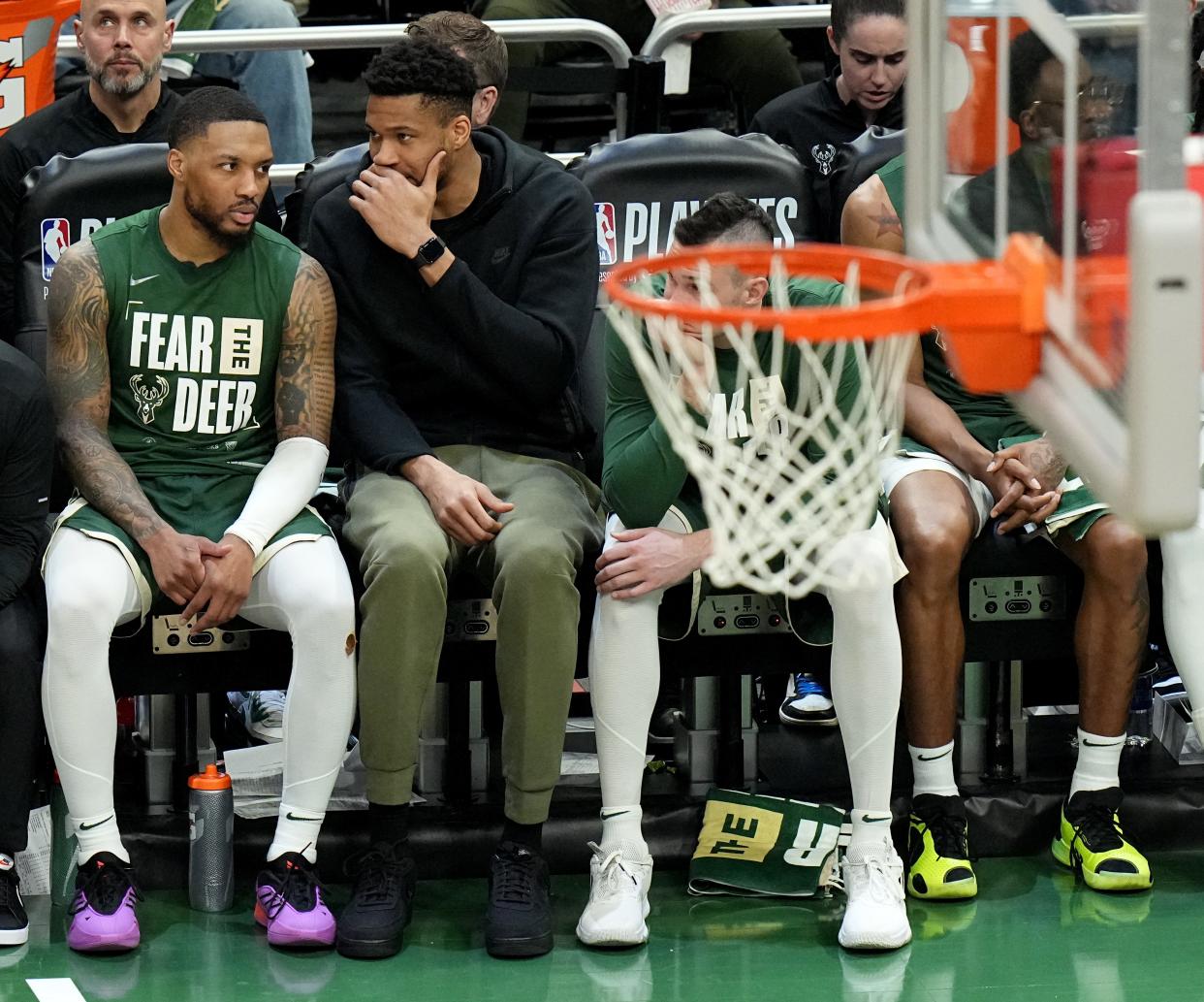 Bucks guard Damian Lillard listens to injured Giannis Antetokounmpo during the second half of Game 1 of the Pacers series Sunday.