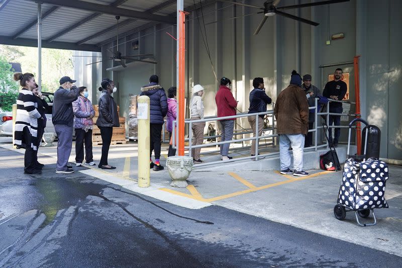 Community members stand in line outside of The Community Assistance Center food pantry, in Atlanta