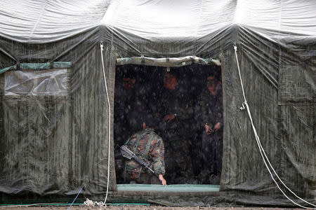 South Korean soldiers take cover from the rain during a combined arms collective training exercise in Pocheon, South Korea September 19, 2017. REUTERS/Kim Hong-Ji