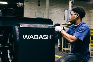 A Wabash employee installs a mudflap with the new logo